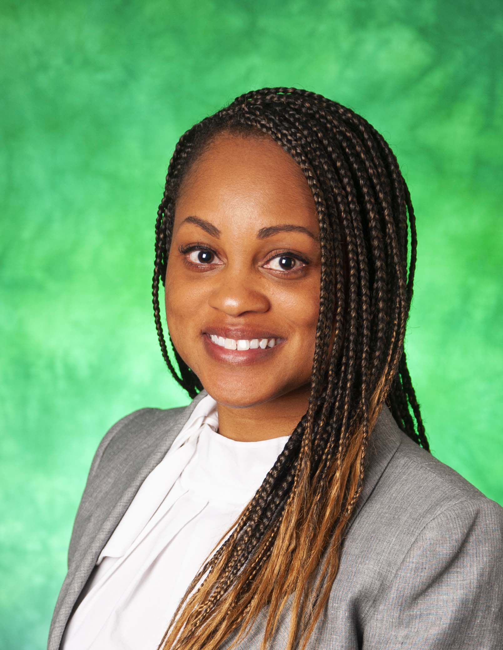 Woman wearing a gray blazer and white blouse. 
